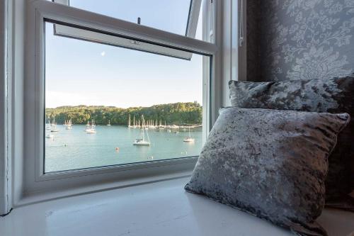 a window with a view of a body of water with boats at Mishnish Hotel in Tobermory