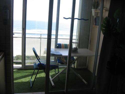 a table and chairs in a room with a view of the beach at Studio vue sur la mer au 6ème et dernier étage in Canet-en-Roussillon