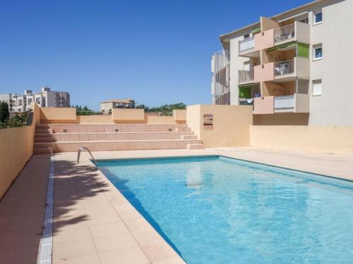 une piscine sur le côté d'un immeuble dans l'établissement Les rives du lac, au Grau-du-Roi