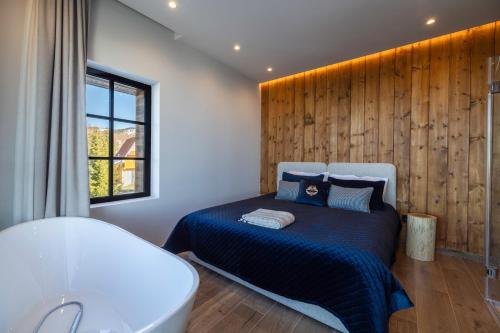 una camera con letto, vasca e finestra di NOOK Kopaonik Luxury Apart & House a Kopaonik