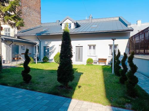 a house with a row of trees in the yard at Fundacja Apartamenty Czterolistna Koniczyna in Przemyśl