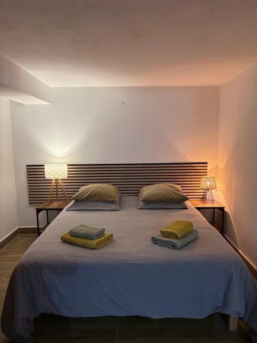 a bedroom with a large bed with two pillows on it at Entre Mer et Montagne in Sartène