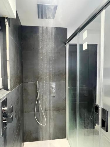 une douche avec une porte vitrée dans une salle de bain dans l'établissement Beach house Maison de plage les pieds dans l eau, à Plérin