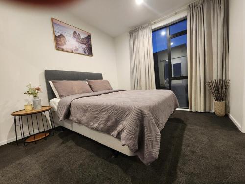 a bedroom with a large bed and a window at Modern Central 1 Bedroom Apt in Lower Hutt