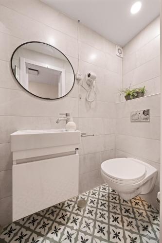 a white bathroom with a sink and a mirror at Havatselet 19 By Isrentals in Jerusalem