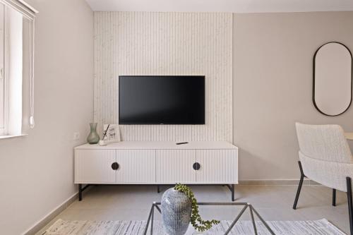 a living room with a tv on a white cabinet at Havatselet 19 By Isrentals in Jerusalem