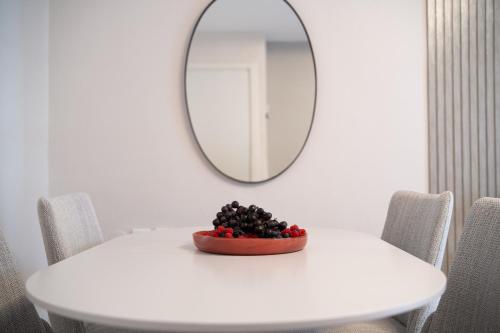 a bowl of berries on a white table with a mirror at Havatselet 19 By Isrentals in Jerusalem
