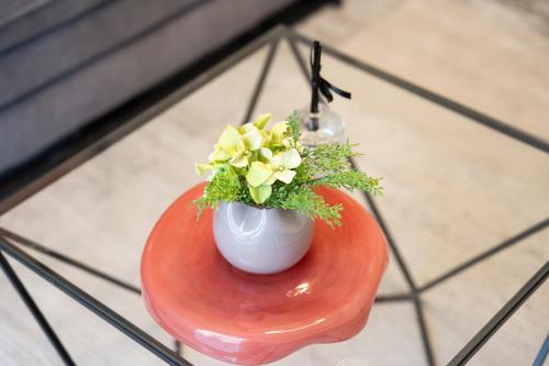 a vase with flowers in it sitting on a table at Havatselet 19 By Isrentals in Jerusalem
