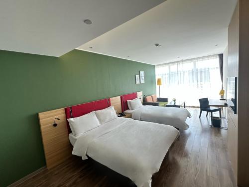 Ένα ή περισσότερα κρεβάτια σε δωμάτιο στο Merlinhood Hotel Hohhot East Gate of University of Technology