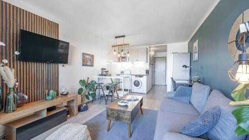 un salon avec un canapé et une télévision sur un mur dans l'établissement CASA L'ALBA - Piscine Lagon - Plage, à Cogolin