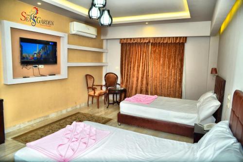 a hotel room with two beds and a tv at La mer Hotel in Alexandria