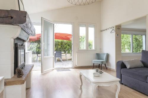 un salon avec un canapé et une cheminée dans l'établissement Gîte du jardin de Charlotte - Ancenis St Géréon, à Saint-Géréon