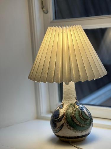 a vase sitting on a table with a lamp at Hotel Klostergaarden in Allinge