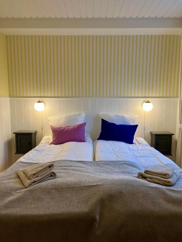 a bedroom with a large bed with two pillows at Hotel Klostergaarden in Allinge