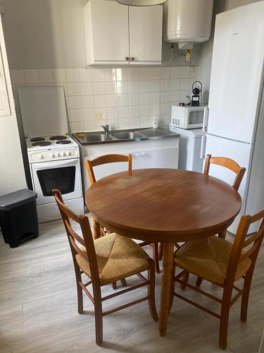 a kitchen with a wooden table and chairs in it at Appartemment T3 (2 chambres) cœur de Candé WIFI in Candé