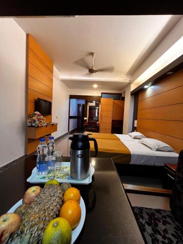 a hotel room with a tray of fruit on a table at Kediyoor Hotels in Udupi
