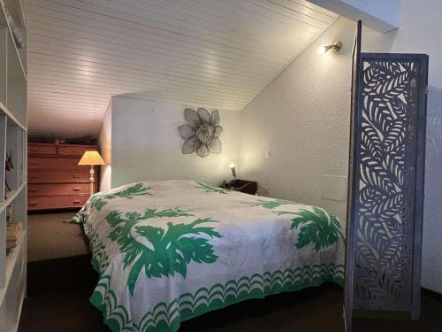 - une chambre avec un lit orné d'une fleur sur le mur dans l'établissement Appt T2 Mezzanine 4 couchages BANYULS SUR MER BN050-A05, à Banyuls-sur-Mer