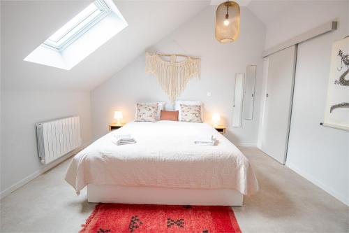 - une chambre blanche avec un grand lit et un tapis rouge dans l'établissement AU VINCI Appartement 4 personnes, à Amboise