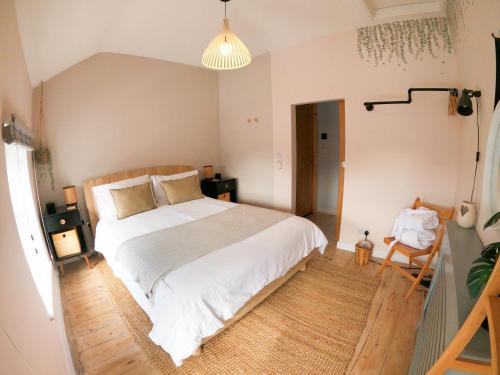 a bedroom with a white bed and a wooden floor at Relaxing Coastal Retreat for 2 Hot Tub Log Fire in Tywyn