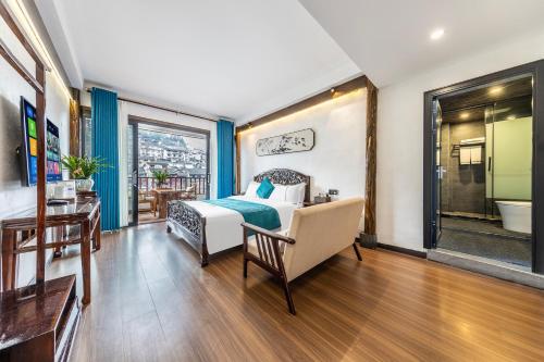 a bedroom with a bed and a desk and a window at Jiuqi Tongnian High-end River View B&B in Fenghuang