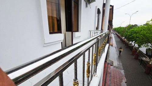 a person walking on a balcony of a building at Sultan hotel boutique in Andizhan