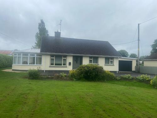 a white house with a large yard at Laurel cottage in Omagh