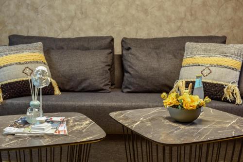 a couch with pillows and a bowl of flowers on a table at Havatselet 19 By Isrentals in Jerusalem