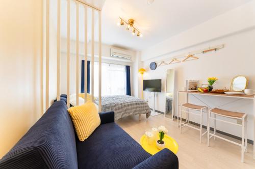 a living room with a blue couch and a kitchen at Felizstay Tokyo in Tokyo