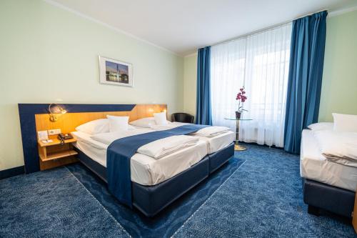 a hotel room with two beds and a window at Hotel Hanseport Hamburg in Hamburg