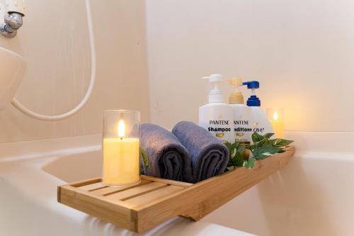 a candle and towels on a wooden tray on a bathroom sink at Felizstay Tokyo in Tokyo