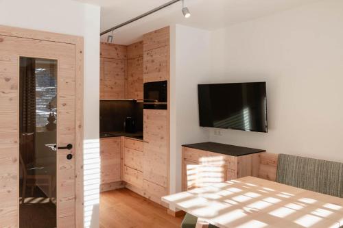 a living room with a television and a table at Rainer Apartment in Sillian