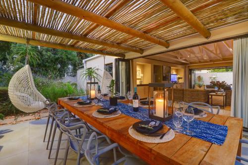 a large wooden table with chairs and a dining room at Scallop Lodge in Plettenberg Bay