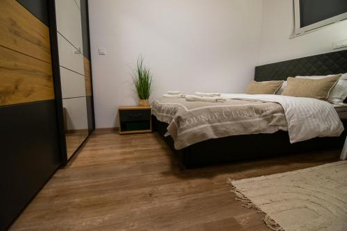 a bedroom with a large bed and a wooden floor at Apartments Villa Prod in Ljubljana