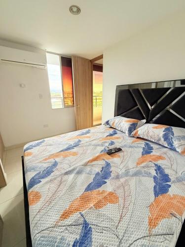 a bedroom with a bed with a colorful comforter at Cómodo aparta estudio cerca a 5 min del aeropuerto in Cúcuta