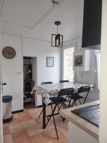 une cuisine et une salle à manger avec une table et des chaises dans l'établissement Les Sables - Proche Plage- Couchage 4 personnes, à Varaville