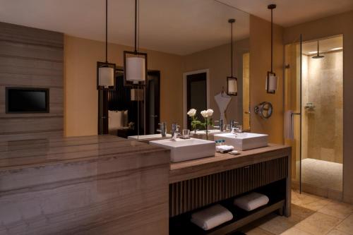 a bathroom with two sinks and a large mirror at Kempinski Hotel Gold Coast City in Accra