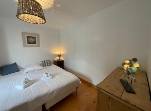 une chambre avec un lit et une table en bois dans l'établissement Les Sables - Proche Plage- Couchage 4 personnes, à Varaville