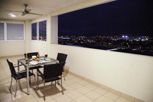 a dining table and chairs in a balcony with a view at Cairns Central Plaza Apartment Hotel Official in Cairns