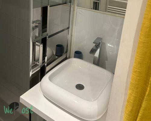un lavabo blanc dans une salle de bain avec un miroir dans l'établissement Jasmine-Close to station,Grd Palais,Zénith&Center, à Lille