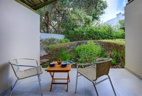 two chairs and a table on a patio at Scallop Lodge in Plettenberg Bay