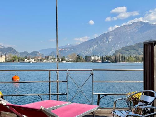 a deck with a table and chairs next to a body of water at Excelsior Lake View in Riva del Garda