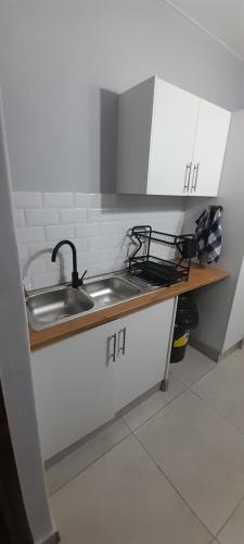 a kitchen counter with a sink and a stove at Unwind and Relax in Amanzimtoti