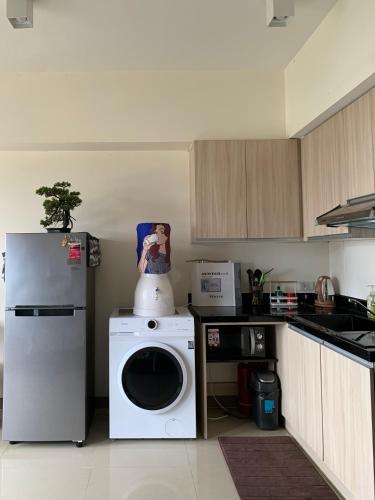 a kitchen with a washing machine and a refrigerator at Cozy Studio, super fast internet, workspace and washer in Cebu City