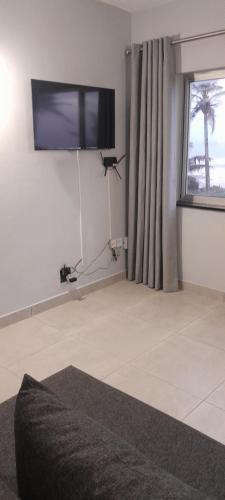 a living room with a flat screen tv on the wall at Unwind and Relax in Amanzimtoti