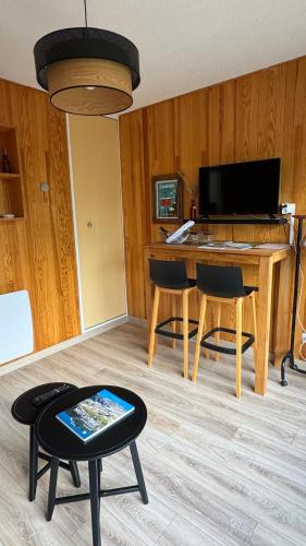un salon avec un bureau et une table avec des chaises dans l'établissement Studio au cœur d auron 118, à Saint-Étienne-de-Tinée