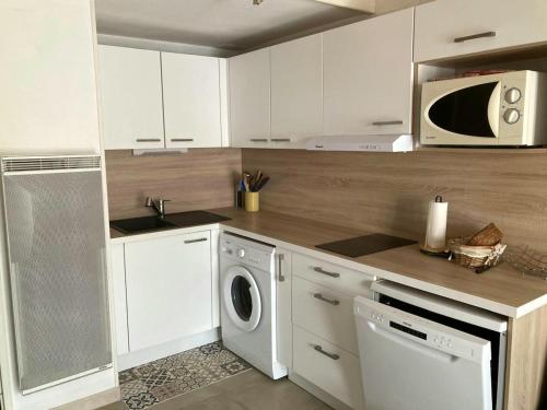 une cuisine avec un lave-linge et un micro-ondes dans l'établissement Beach house - 6 people - parking, à Frontignan