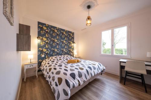 a bedroom with a bed and a desk and a window at Villa de la Salmonière - Maison avec piscine et jardin clos in La Roche-Blanche