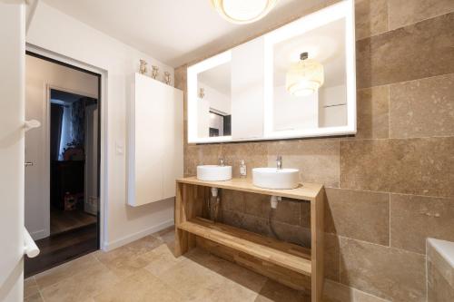 a bathroom with two sinks and a mirror at Villa de la Salmonière - Maison avec piscine et jardin clos in La Roche-Blanche