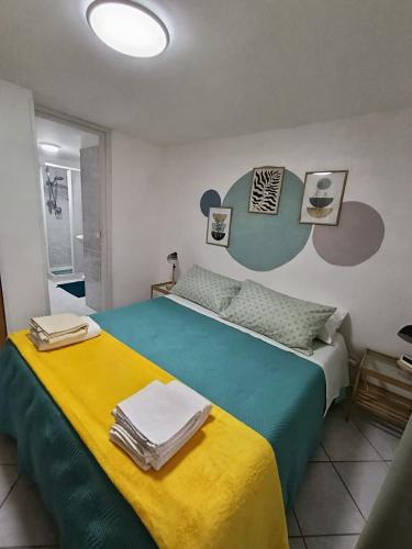 a bedroom with a bed with a yellow and green blanket at Guarda l'alba in Altavilla Milicia