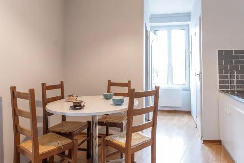 a dining room with a white table and chairs at grand studio ? 35m² ? centre ? 4pers/2lits ? cuisine ? wifi in Candé